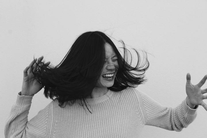 A person laughing, hair in motion.